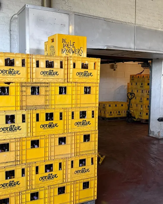 Gestapelde gele Oerbier-bakken vol flessen bij de warme kamer