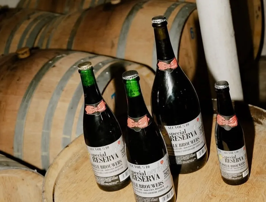 Flessen Oerbier Reserva op een eiken vat in de kelder