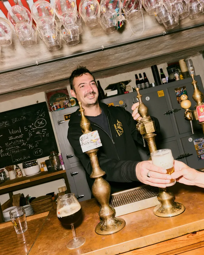 De barman tapt een glas in de Oerbar