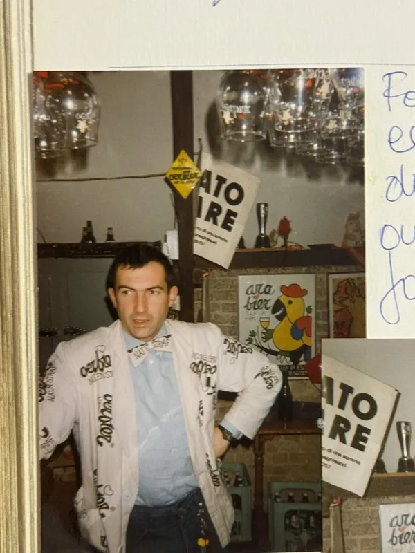 Een man in een jasje vol Oerbier-opdruk aan de toog
